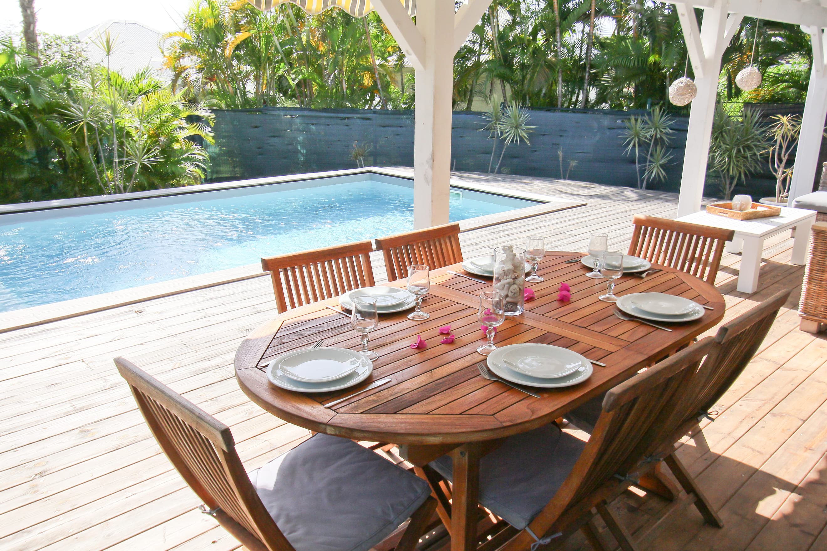 Espace repas sur la terrasse en bois de la Villa Alizé