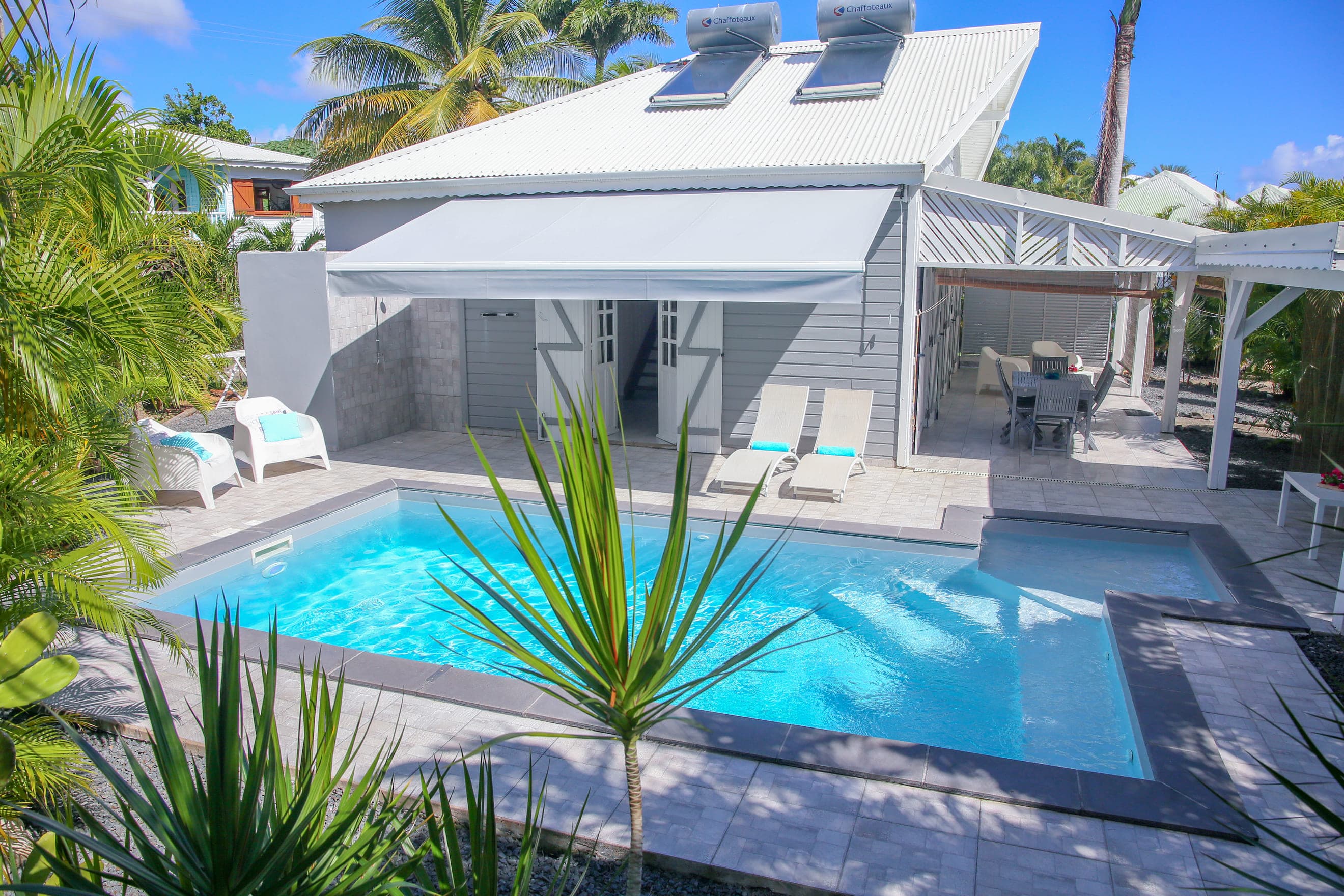 La Villa Bahia, sa case créole grise et sa piscine au sel vues depuis le jardin