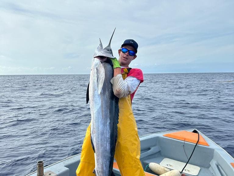 Un wahoo remonté à bord, la mer ouverte derrière