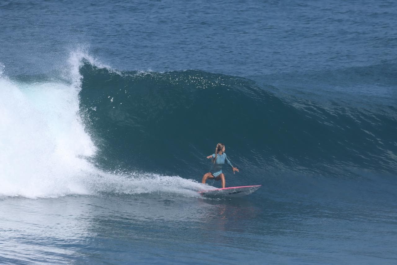 Surfeuse sur une vague du spot du Helleux à Sainte-Anne