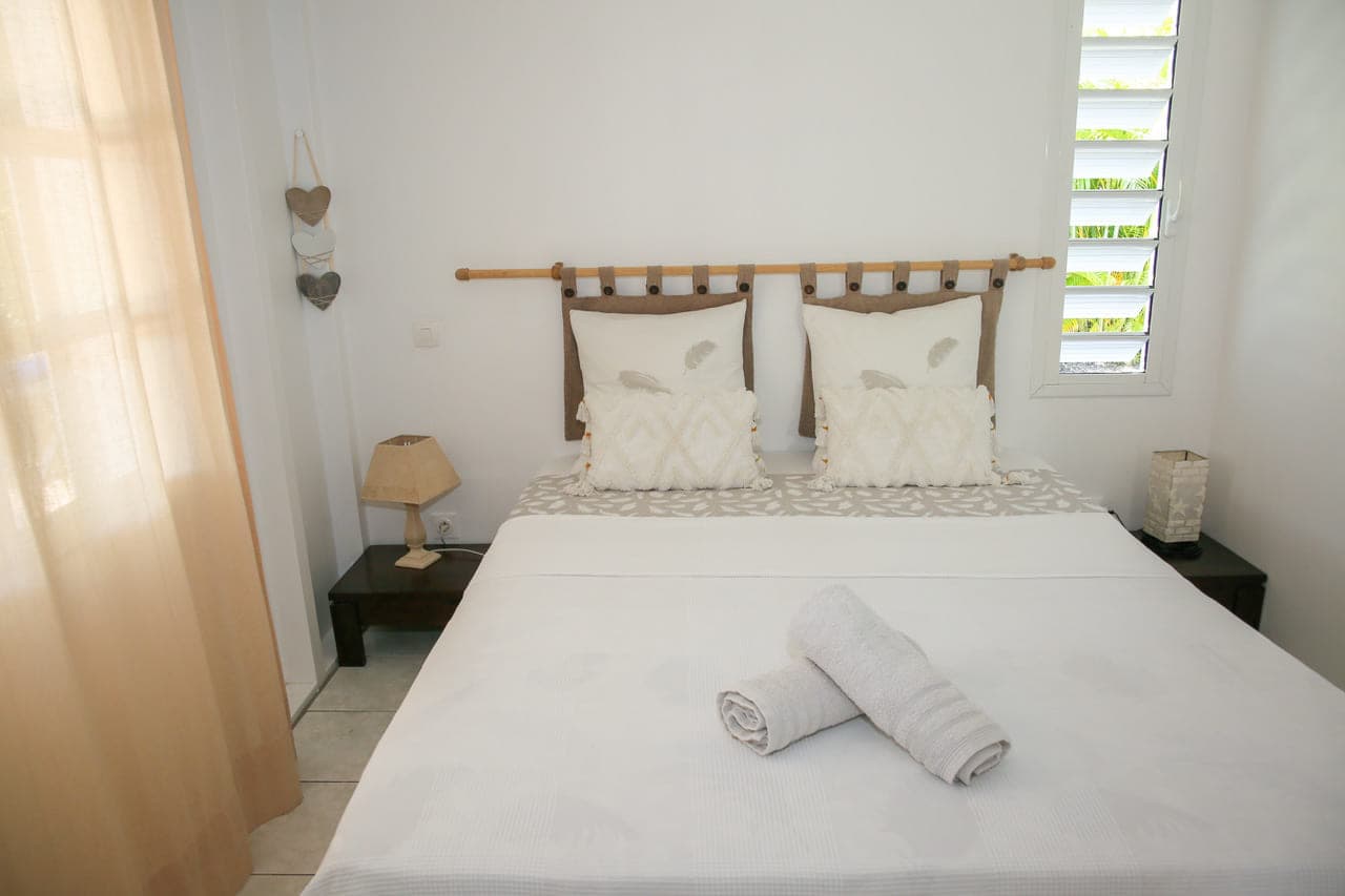 Première chambre de la Villa Alizé, lit double entre deux tables de chevet