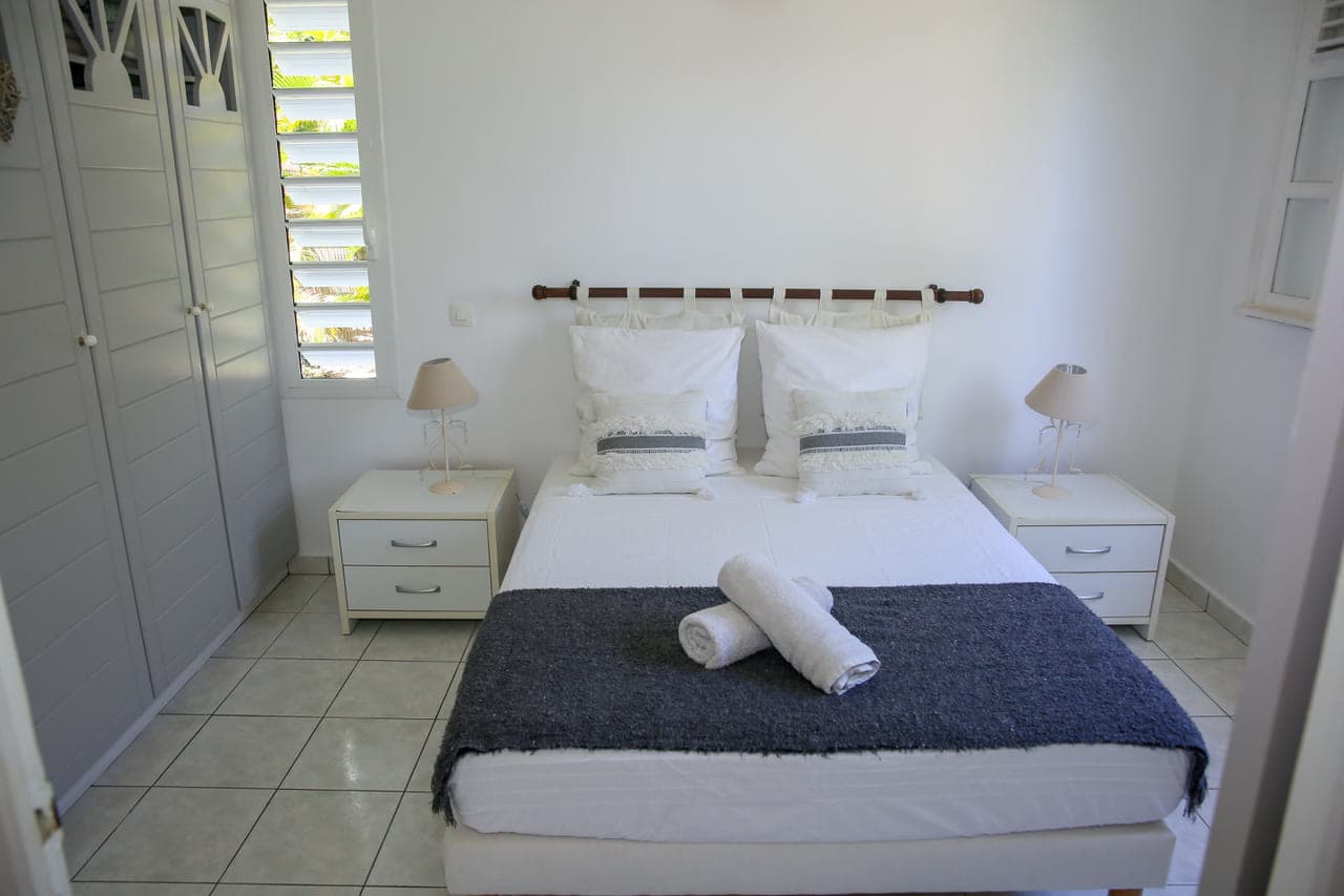 Lit double et ses deux tables de chevet dans la première chambre de la Villa Alizé