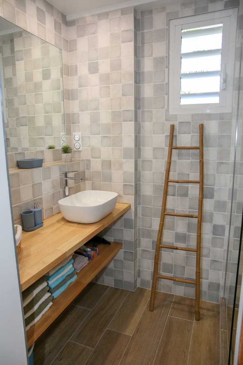 Salle de bain moderne de la Villa Alizé, vasque sur plan en bois et linge fourni