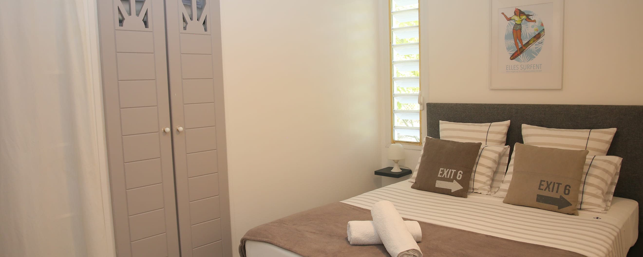 Première chambre de la Villa Bahia, lit double face à une fenêtre à persiennes