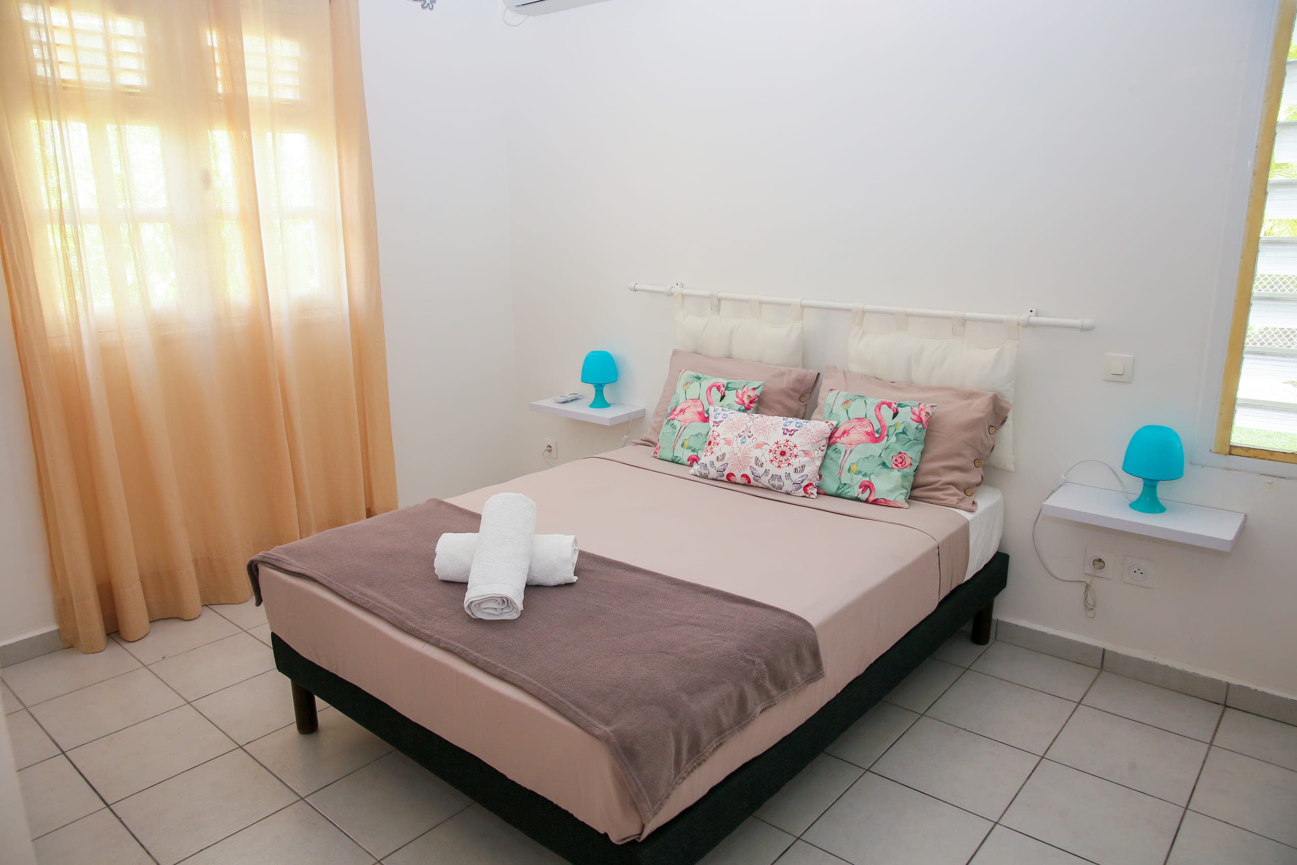 Deuxième chambre de la Villa Bahia, lit double et grande fenêtre sur le jardin