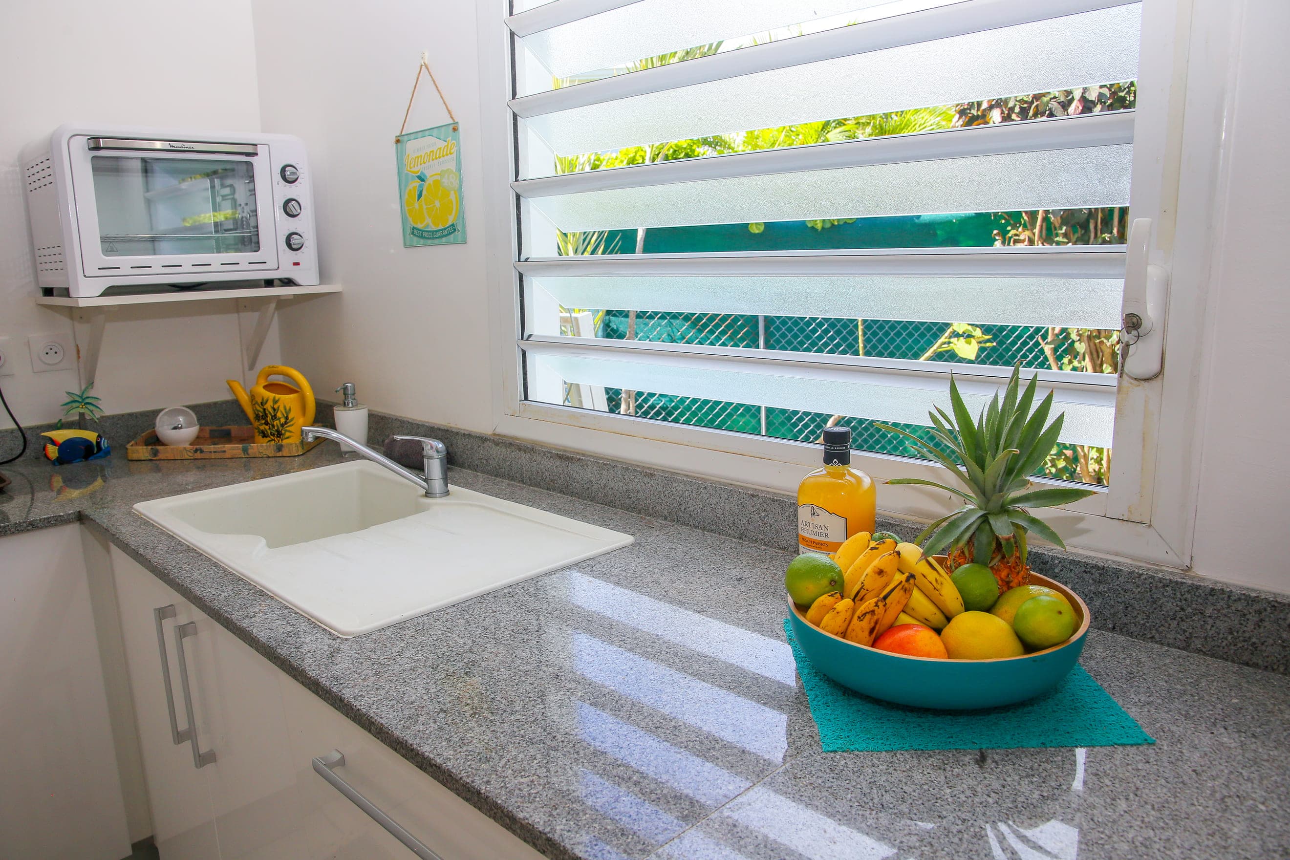 Corbeille de fruits du pays sur le plan de travail en granit de la cuisine de la Villa Bahia