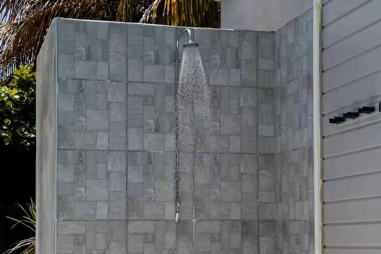 La douche extérieure de la Villa Bahia, adossée au mur de pierre grise