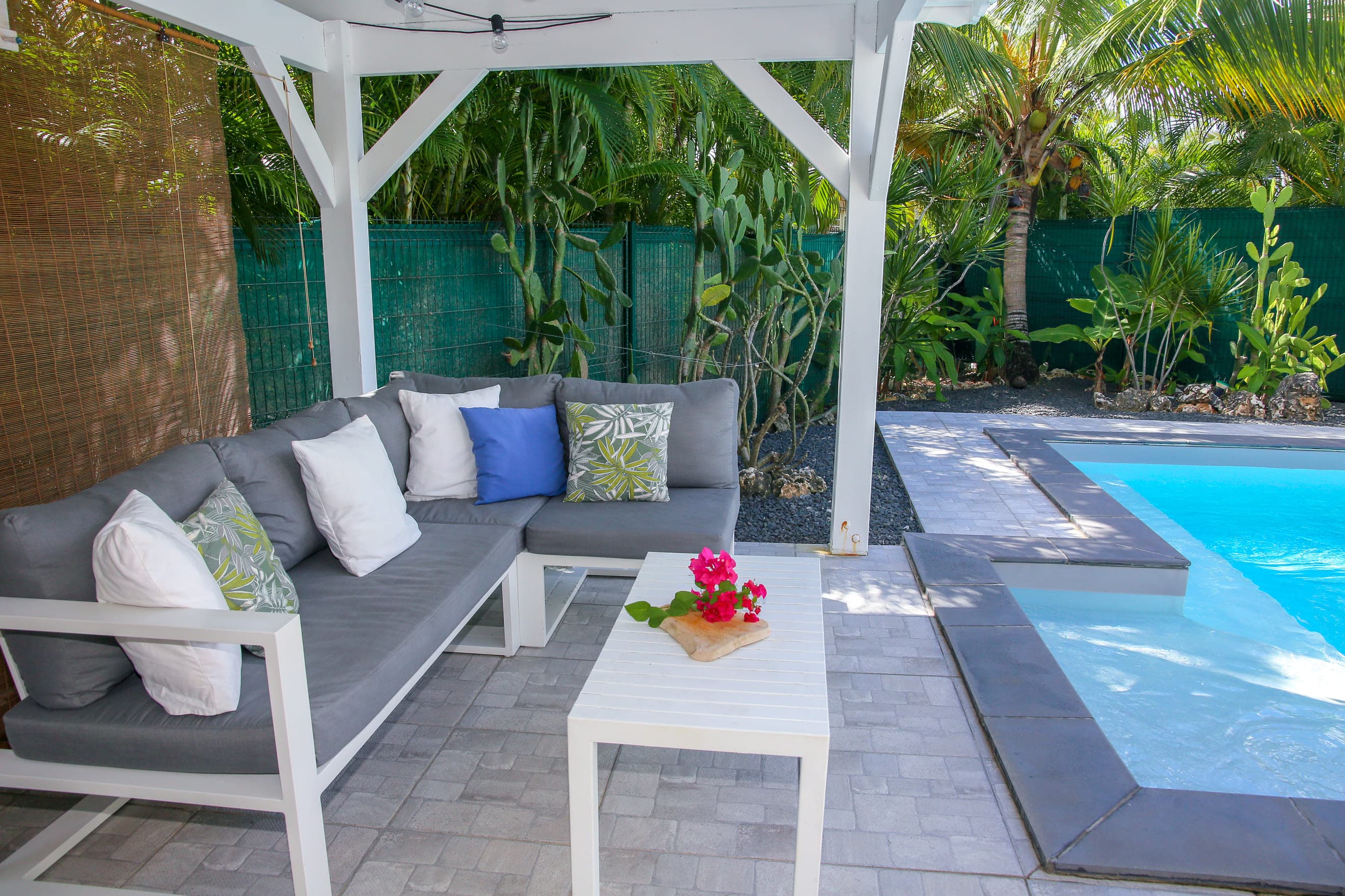 Coussins et fleurs sur la banquette du patio de la Villa Bahia