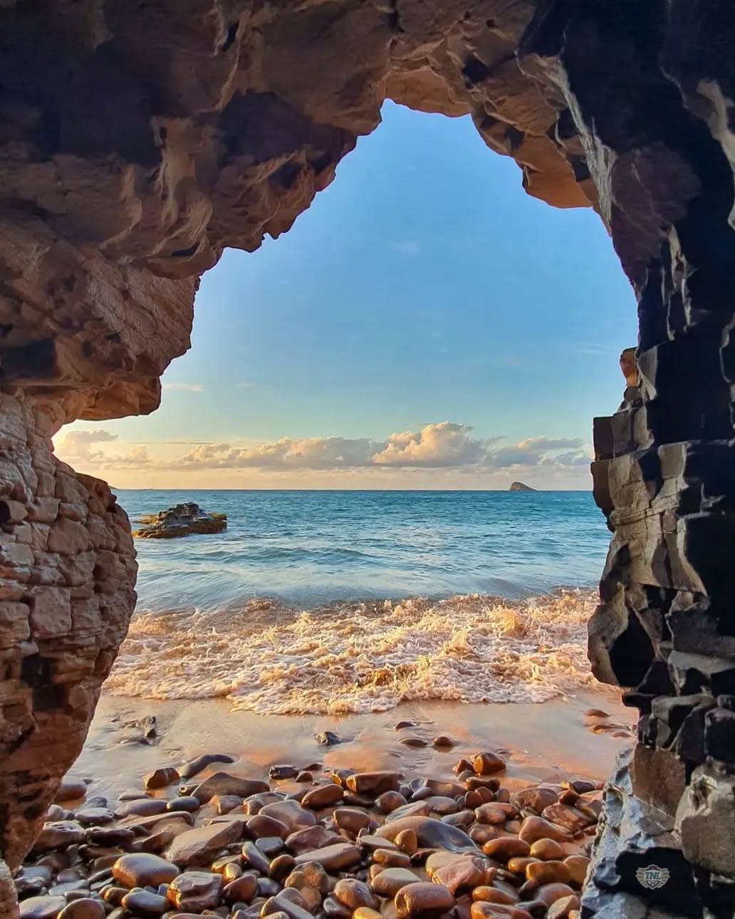 Plage de sable clair aperçue entre deux rochers, en Guadeloupe