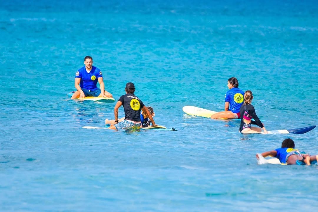 Cours de surf collectif au line-up, moniteur et élèves sur leurs planches
